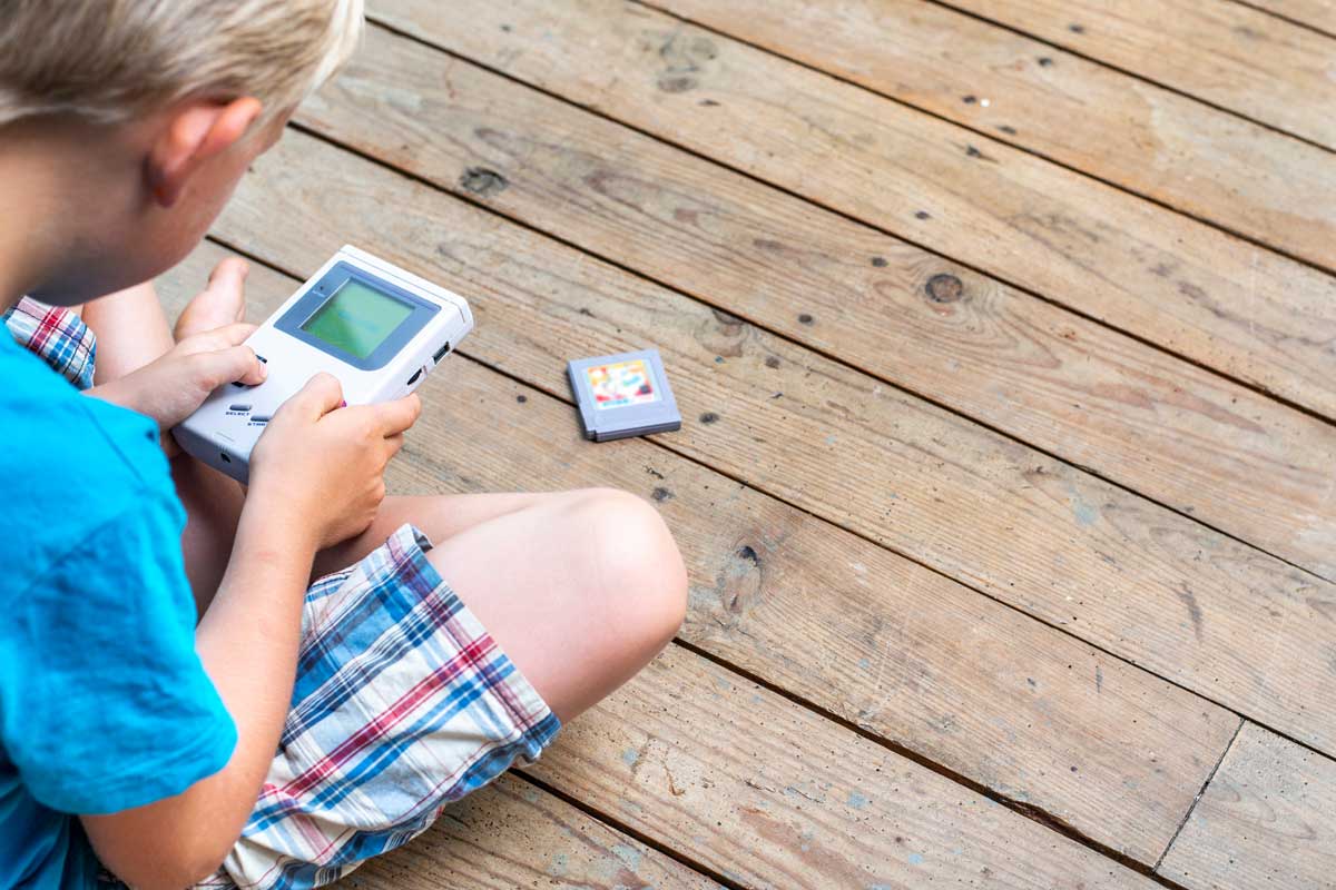 80年代の携帯ゲーム機で遊ぶ少年