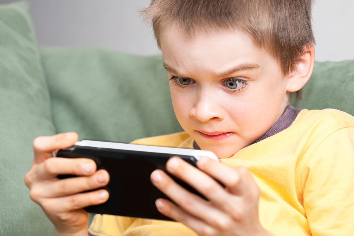 携帯ゲーム機で遊ぶ少年